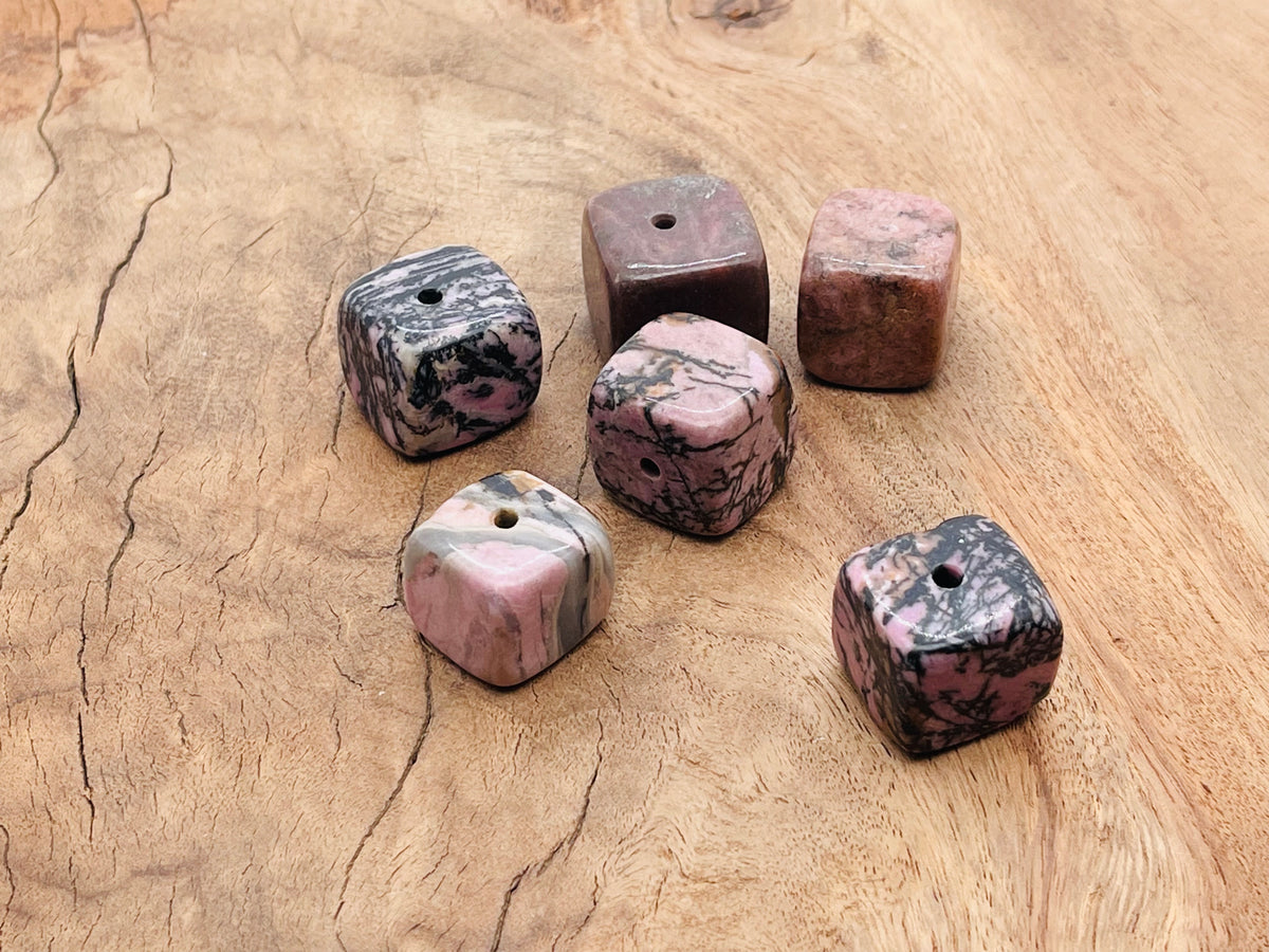 Handmade Rhodonite crystal incense holder with carved stone design for incense sticks, showcasing vibrant pink and black patterns.