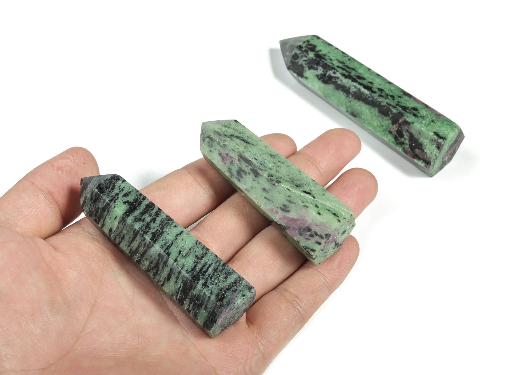Ruby Zoisite obelisk tower crystal from GemstoneGO, showcasing a vibrant, polished gemstone with rich red and green mineral patterns.