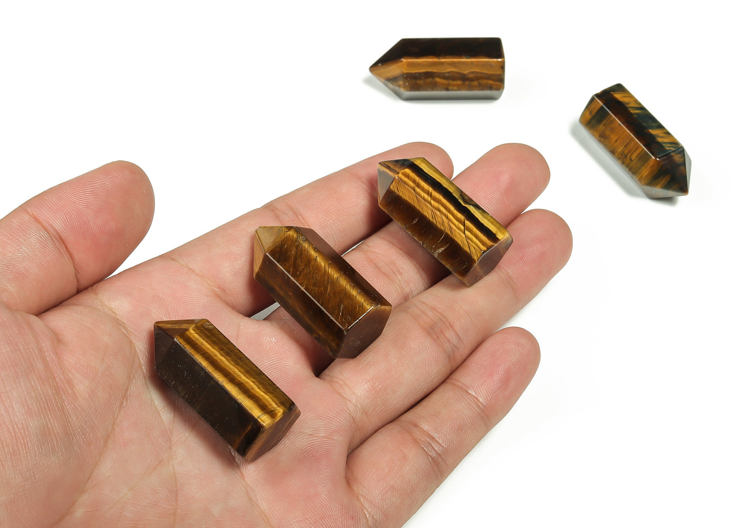 Tiger Eye obelisk tower crystal, 35mm, from GemstoneGO, showcasing its polished, golden-brown stone with natural striations and shine.