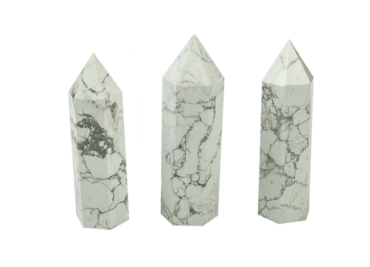Howlite obelisk tower crystal by GemstoneGO, showcasing a white and gray marbled stone with a pointed tip and smooth polished surface.