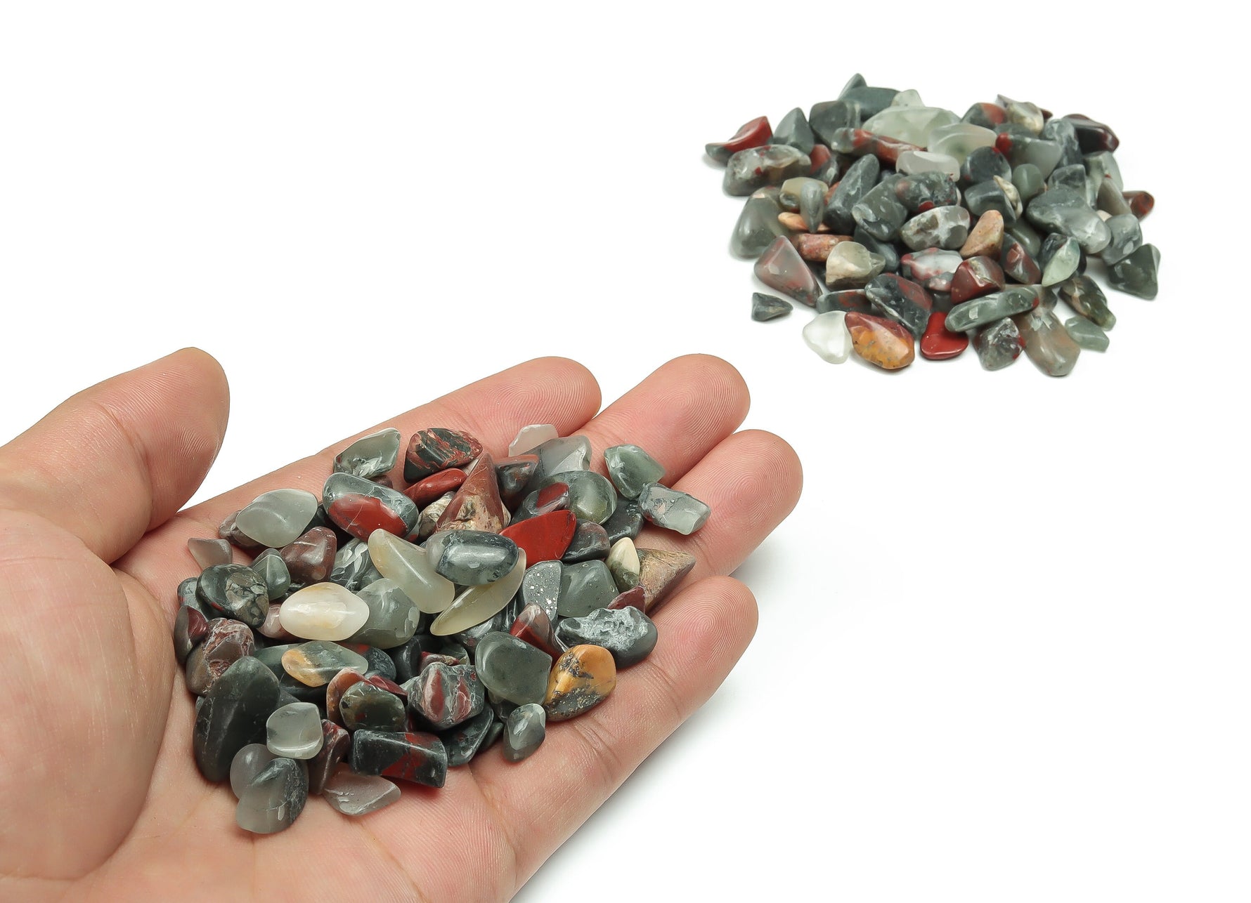 African Bloodstone crystal chips in semi-tumbled 7-12mm size, shown in bulk with rich green and red mineral patterns.