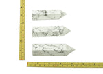 Light gray Howlite obelisk tower crystal from GemstoneGO, with polished surface and pointed top for decorative display.