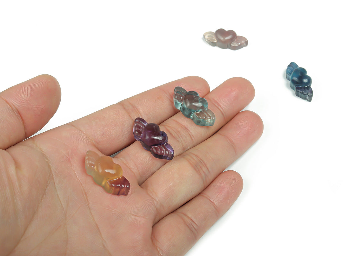 Fluorite Wing Heart Carving gemstone by GemstoneGO, showing a vibrant green and purple carved heart with wing details.
