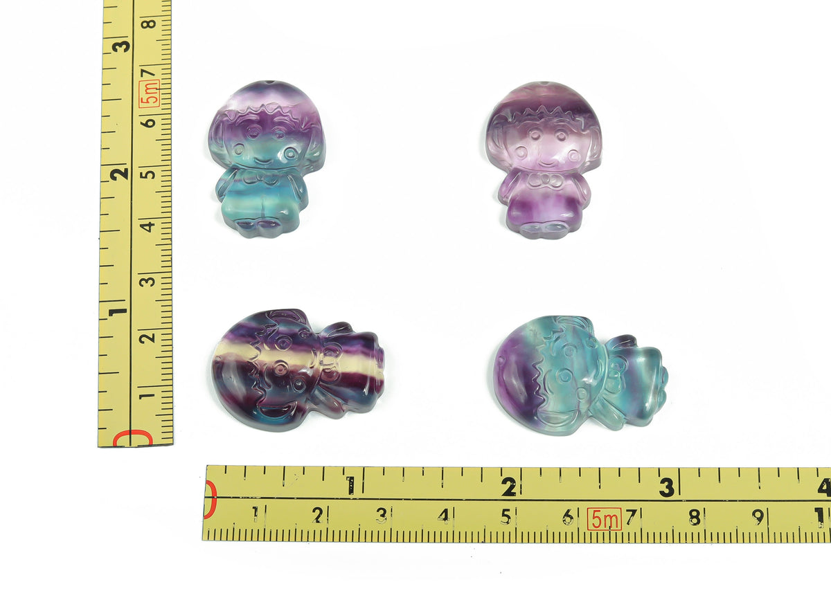 Fluorite girl kid carving gemstone by GemstoneGO, showing detailed carved figure in vibrant purple and green hues.