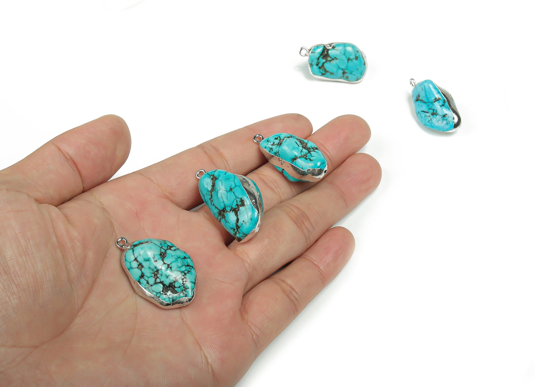 Turquoise crystal pendant with silver edge and turquoise gemstones, showcasing a detailed silver setting and vibrant blue turquoise stones.