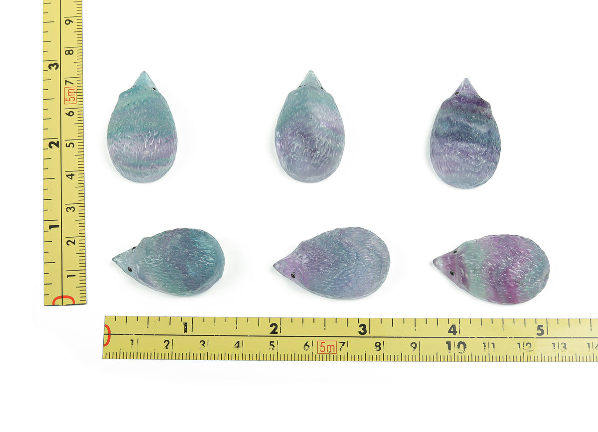 Polished fluorite hedgehog gemstone carving by GemstoneGO, showing vibrant green and purple colors with detailed texture.