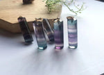 Rainbow fluorite crystal pendant from GemstoneGO featuring vibrant, multicolored fluorite with a polished, teardrop shape.