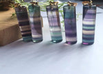Rainbow fluorite crystal pendant from GemstoneGO featuring vibrant, multicolored fluorite gemstone on a delicate chain.