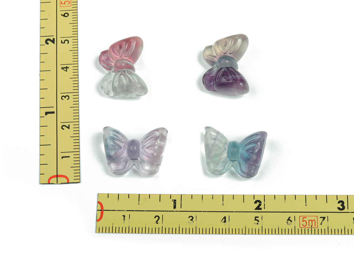 Fluorite butterfly gemstone carving by GemstoneGO, vibrant purple and green hues, detailed butterfly shape and polished surface.