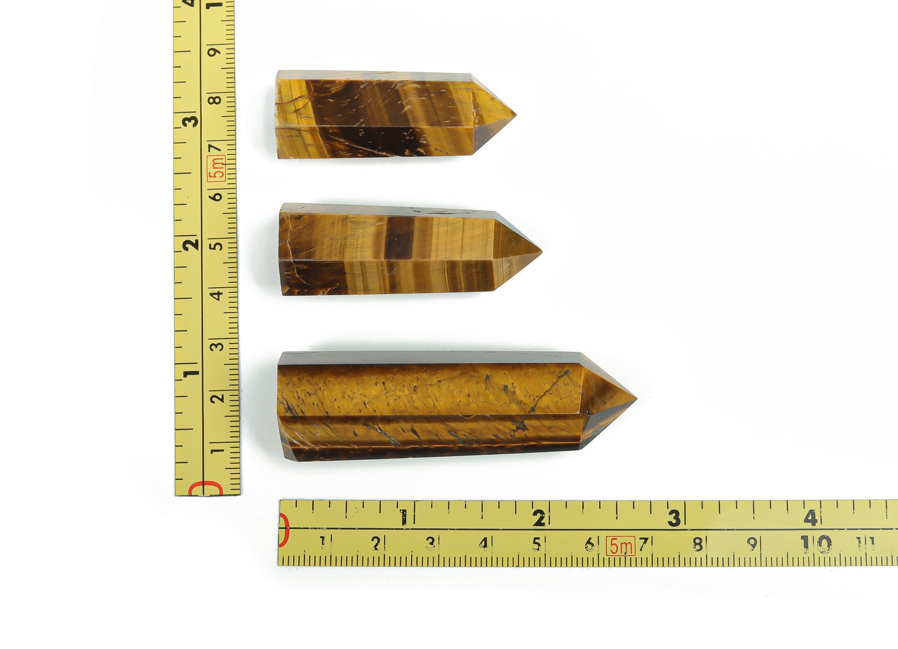 Tiger Eye obelisk tower crystal from GemstoneGO, featuring a polished, golden-brown gemstone with natural striations and a pointed top.