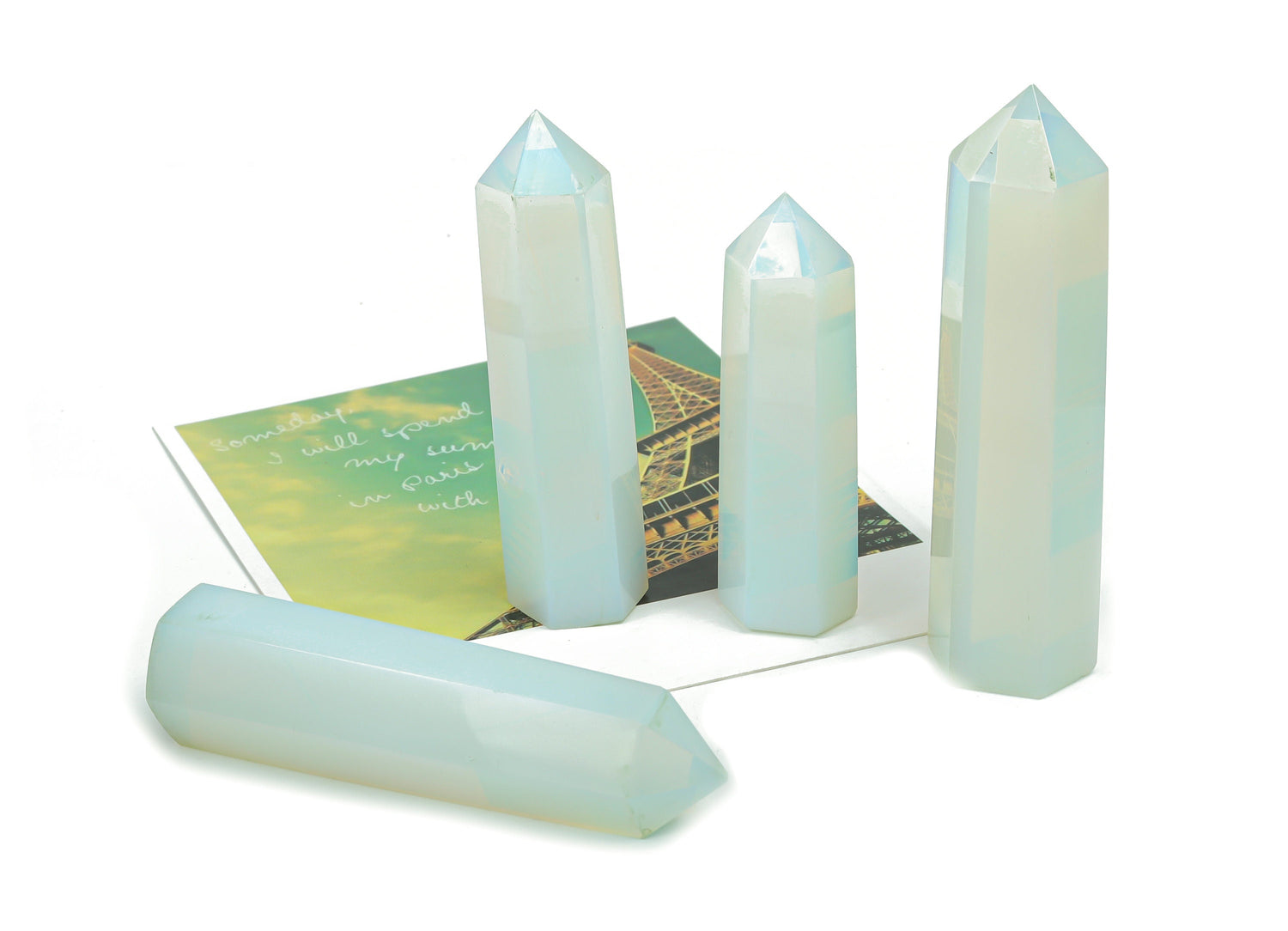 Opalite obelisk tower crystal by GemstoneGO, featuring a smooth, polished white and blue iridescent gemstone obelisk on a stand.