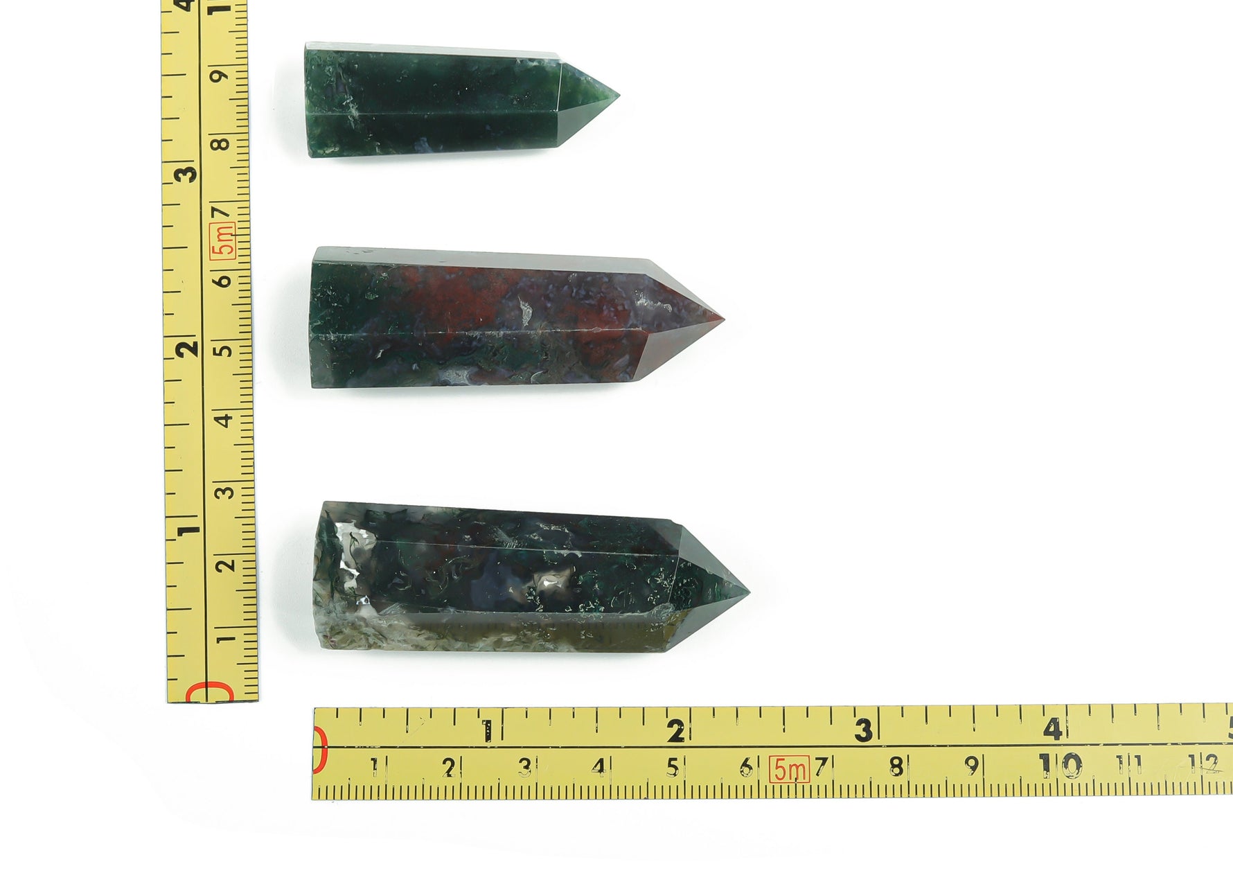 Moss agate obelisk tower crystal from GemstoneGO, natural green and brown mineral specimen with pointed top, polished surface.