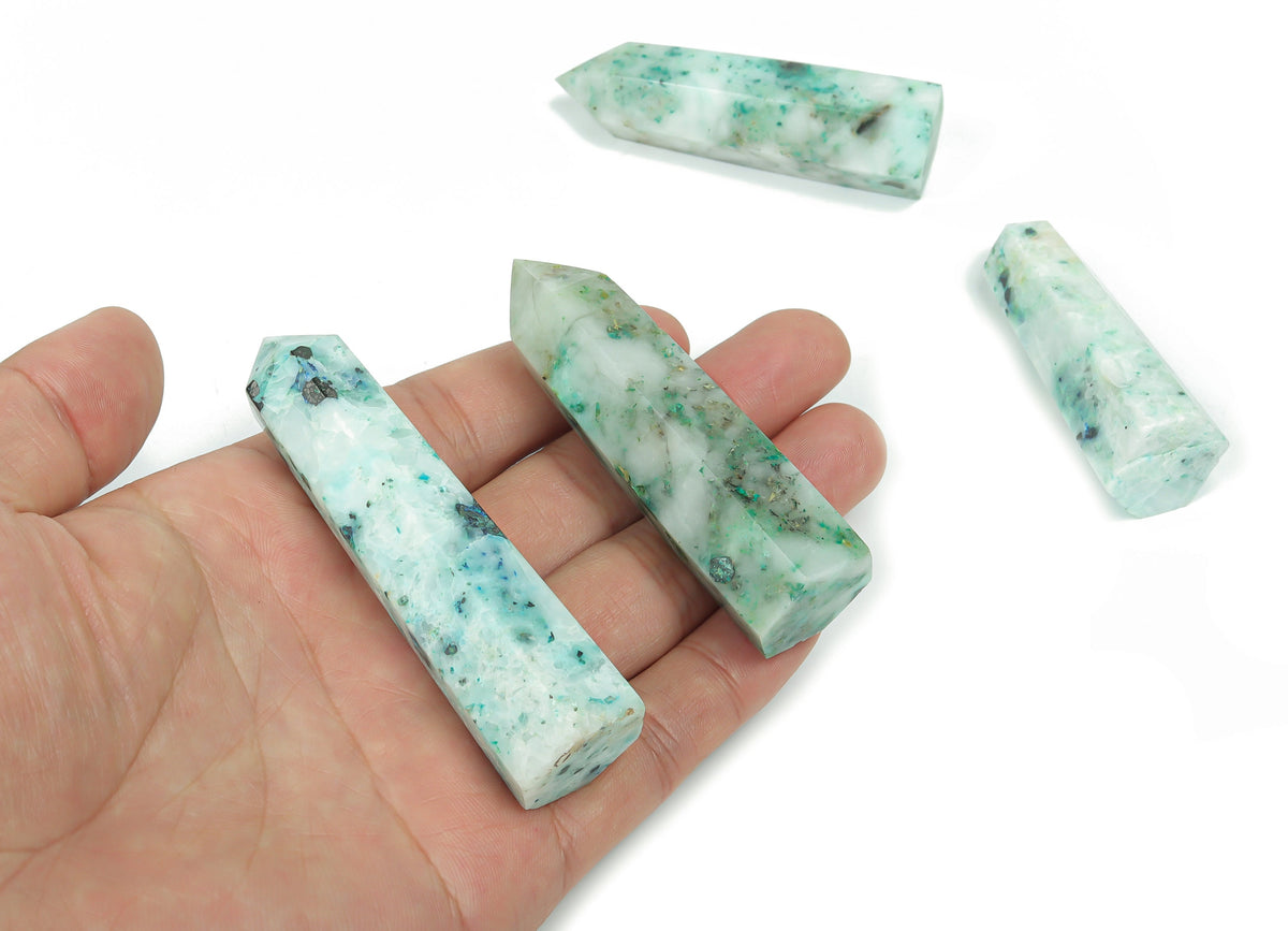 Phoenix Obelisk Tower Crystal from GemstoneGO, a polished clear quartz gemstone sculpture with detailed carving and a pointed top.