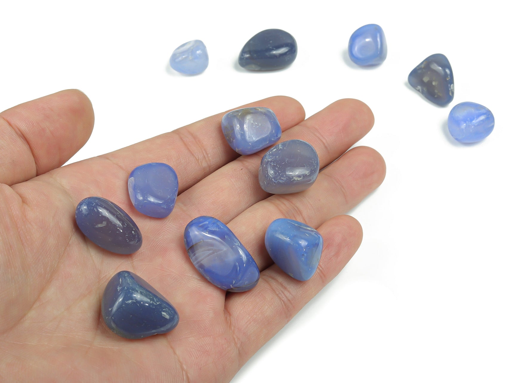 Blue agate tumbled stone from GemstoneGO, showing smooth, polished blue and white banded gemstone with natural patterns.