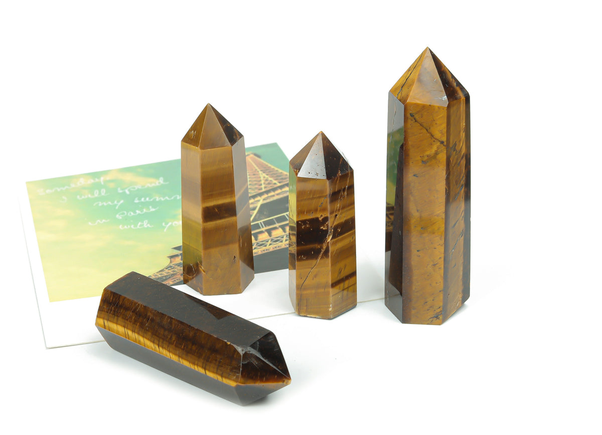 Tiger Eye obelisk tower crystal from GemstoneGO, showcasing a polished, golden-brown gemstone with natural banding and a pointed shape.
