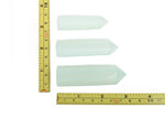 Opalite obelisk tower crystal from GemstoneGO, smooth translucent white gemstone with a pointed top and polished finish.