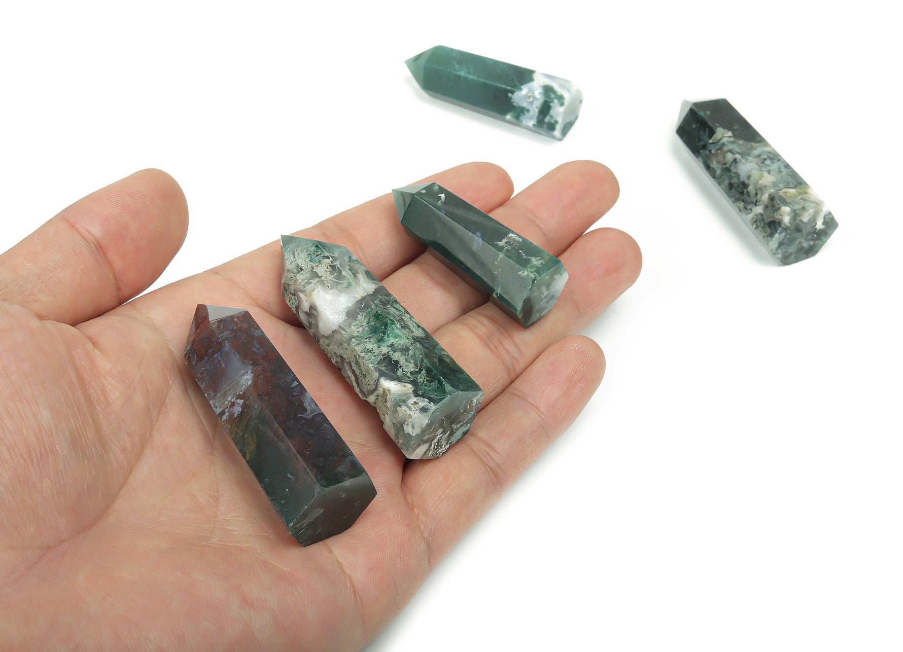 Moss agate obelisk tower crystal from GemstoneGO, showcasing green and brown moss-like patterns on polished stone surface.