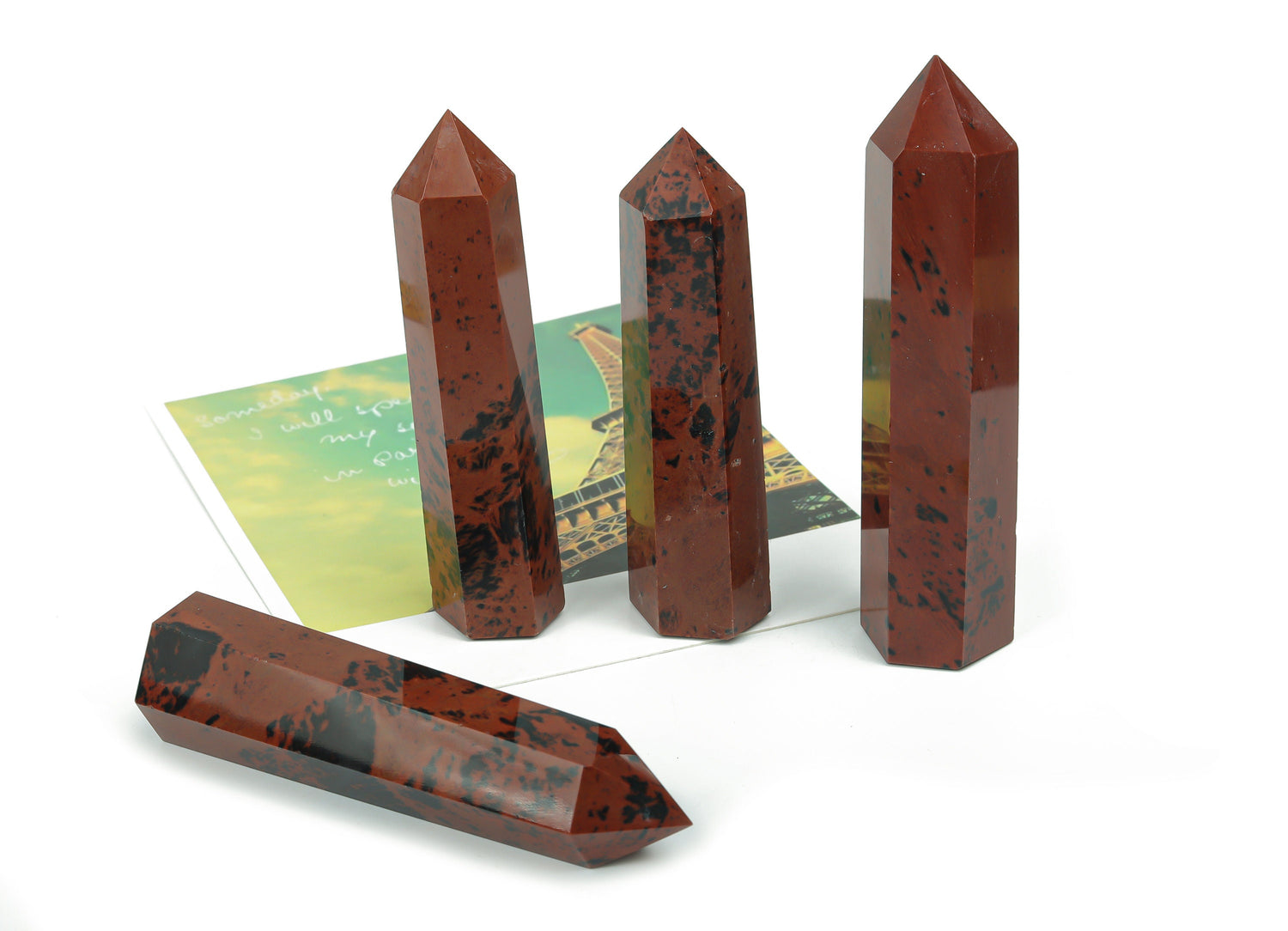 Mahogany Obsidian obelisk tower crystal from GemstoneGO, showcasing a polished, dark brown and reddish stone with natural veining.