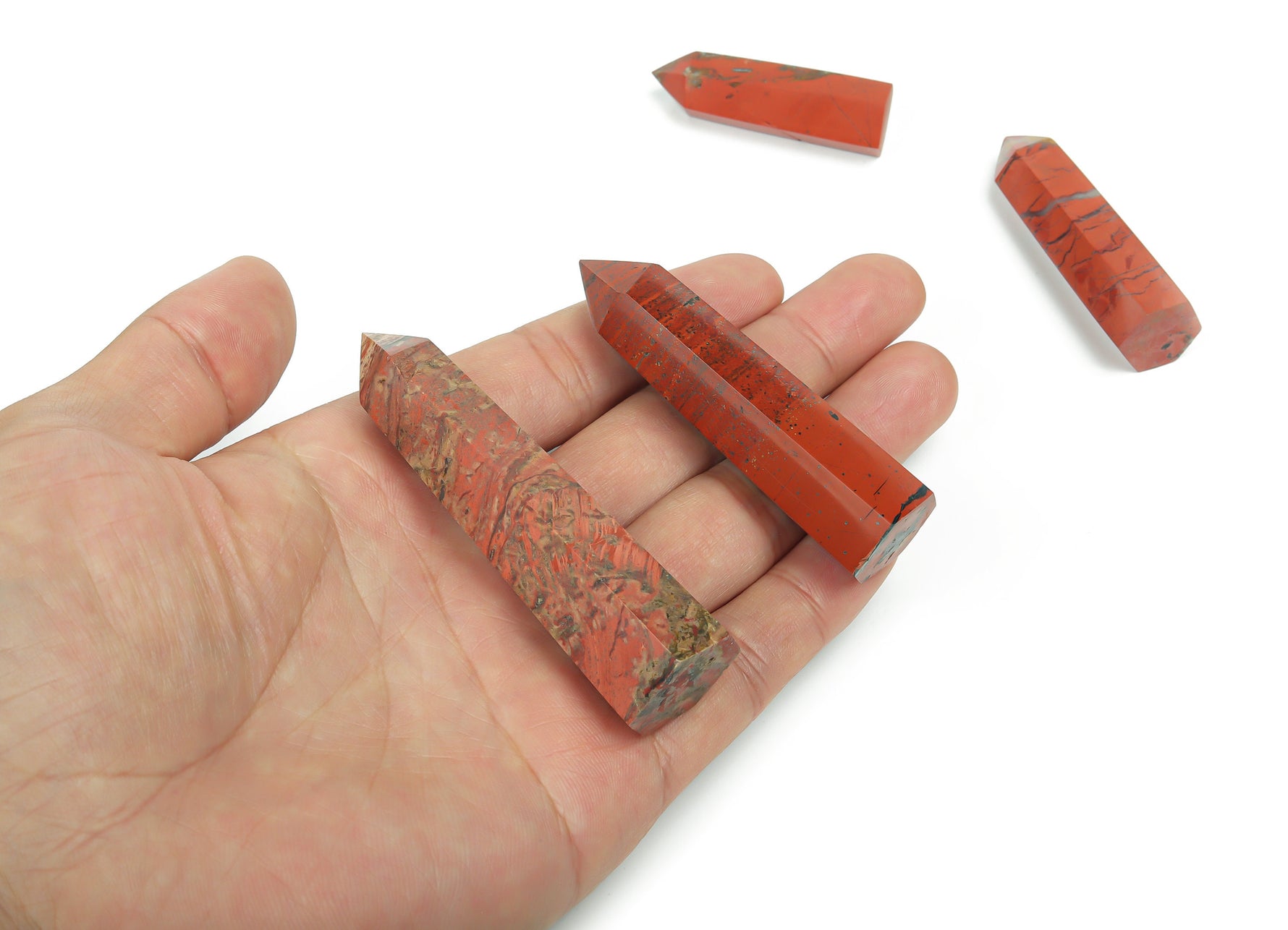 Red Jasper obelisk crystal tower from GemstoneGO, showcasing deep red stone with natural patterns and a pointed top.