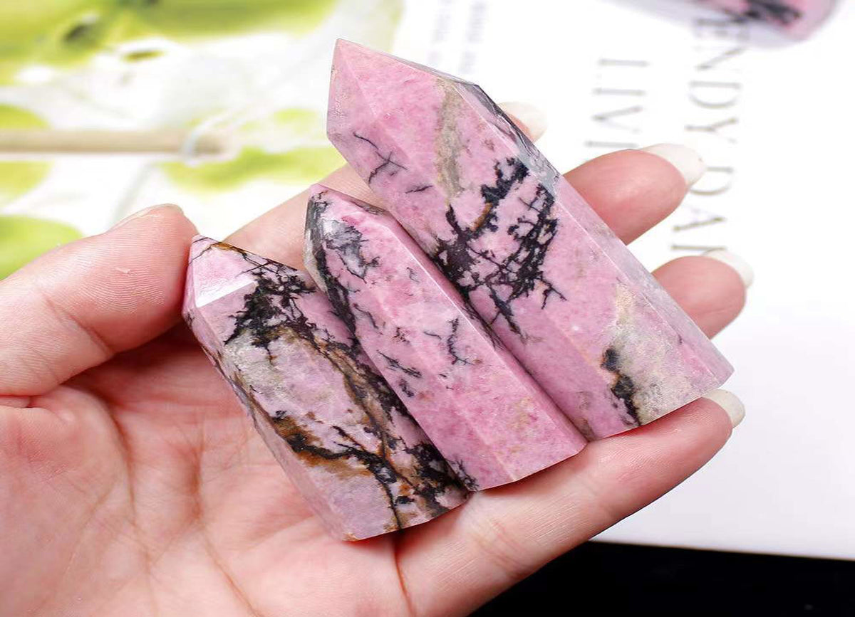 Rhodonite obelisk tower crystal from GemstoneGO showcasing a pink and black polished gemstone sculpture.