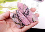 Rhodonite obelisk tower crystal from GemstoneGO showcasing a pink and black polished gemstone sculpture.