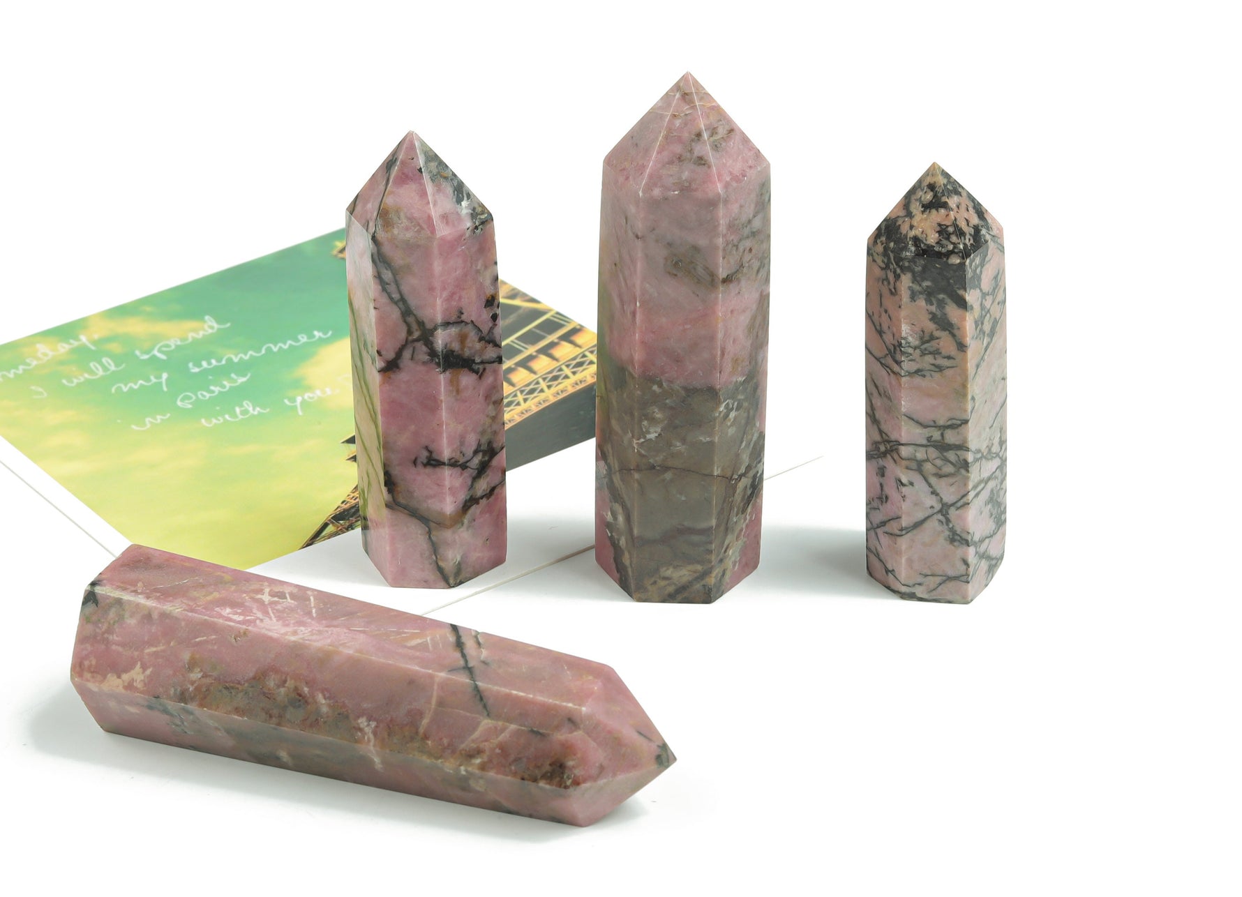 Rhodonite obelisk tower crystal from GemstoneGO, showcasing pink and black layered mineral with polished surface.