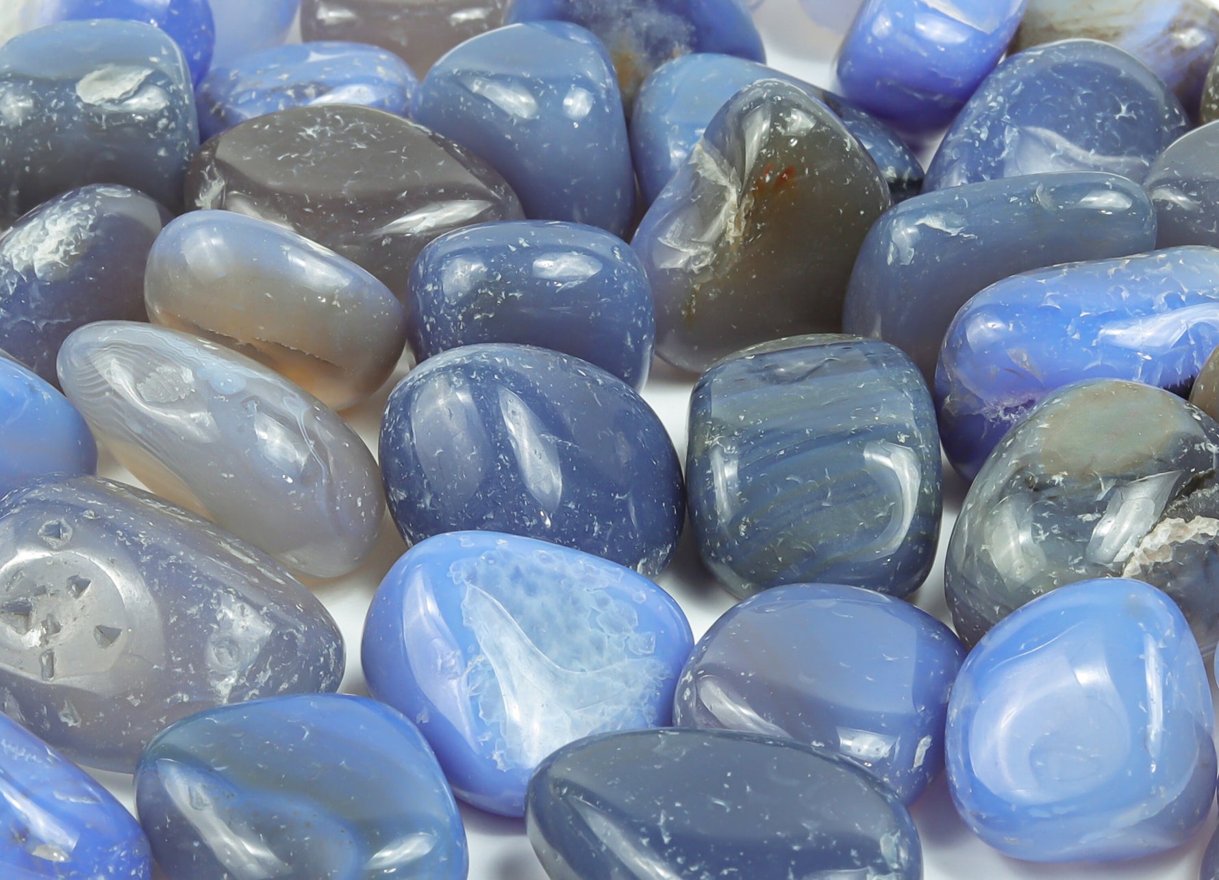 Blue Agate tumbled stone from GemstoneGO, showcasing smooth, polished blue agate with natural banding and vibrant color.