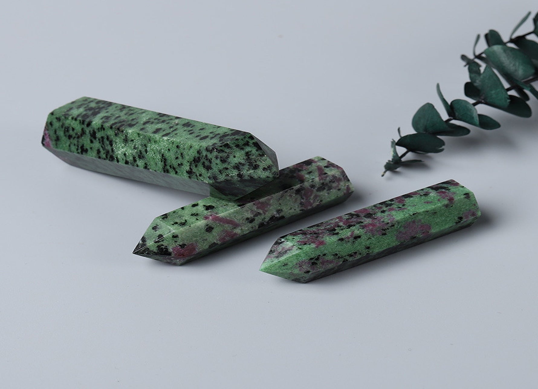 Ruby Zoisite obelisk tower crystal from GemstoneGO, showcasing vibrant red and green mineral patterns in a polished stone.