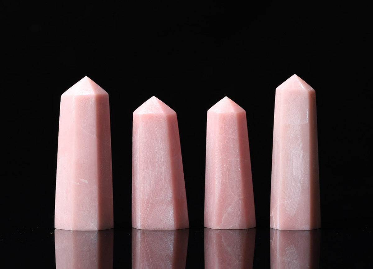 Pink Opal obelisk tower crystal from GemstoneGO with smooth polished surface and natural pink hue on a plain background.