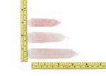 Rose quartz obelisk tower crystal from GemstoneGO, featuring a pink, polished stone with natural crystal details and a pointed top.
