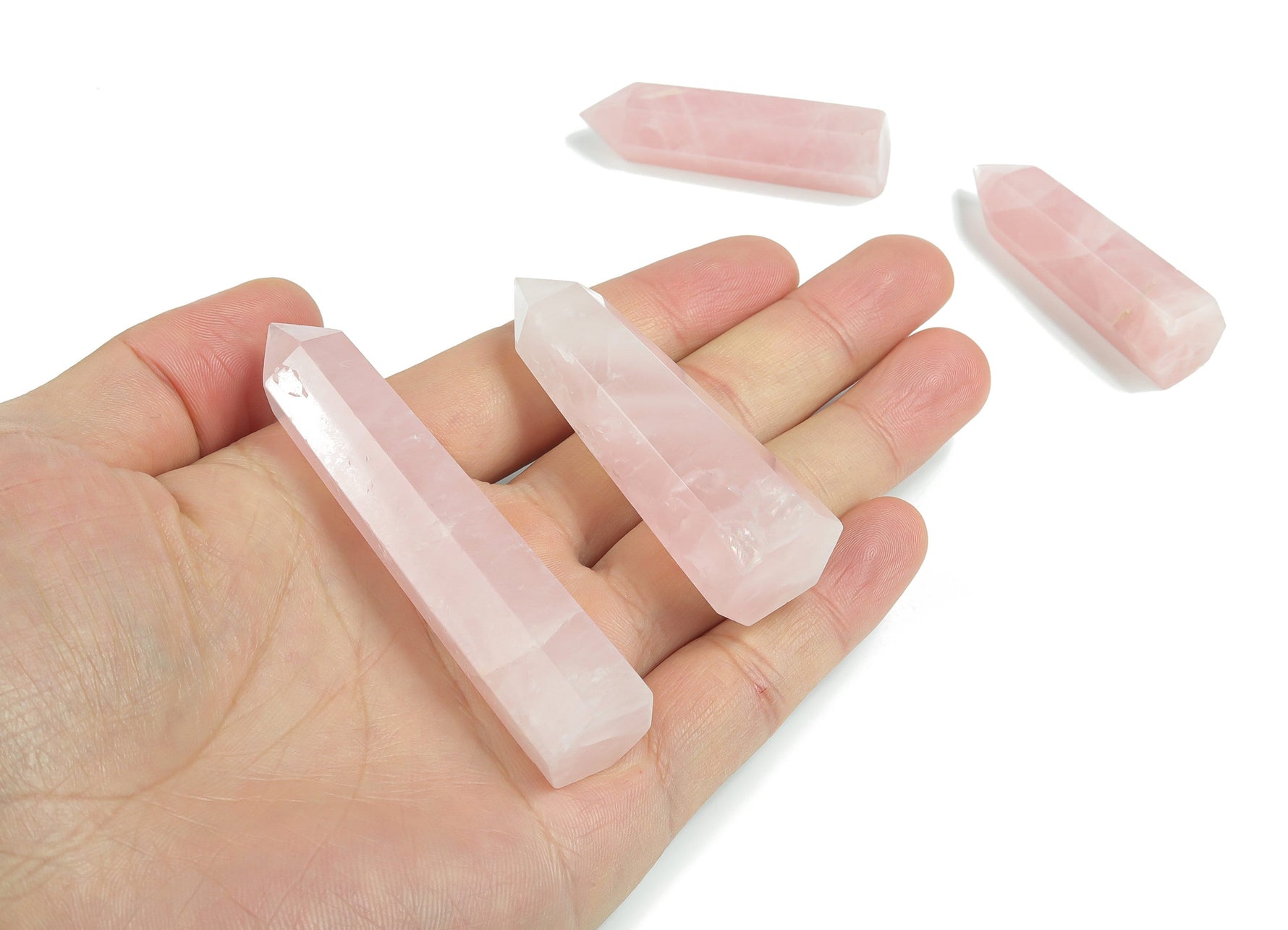 Rose quartz obelisk crystal tower from GemstoneGO, featuring a polished pink gemstone with natural veining and a pointed top.