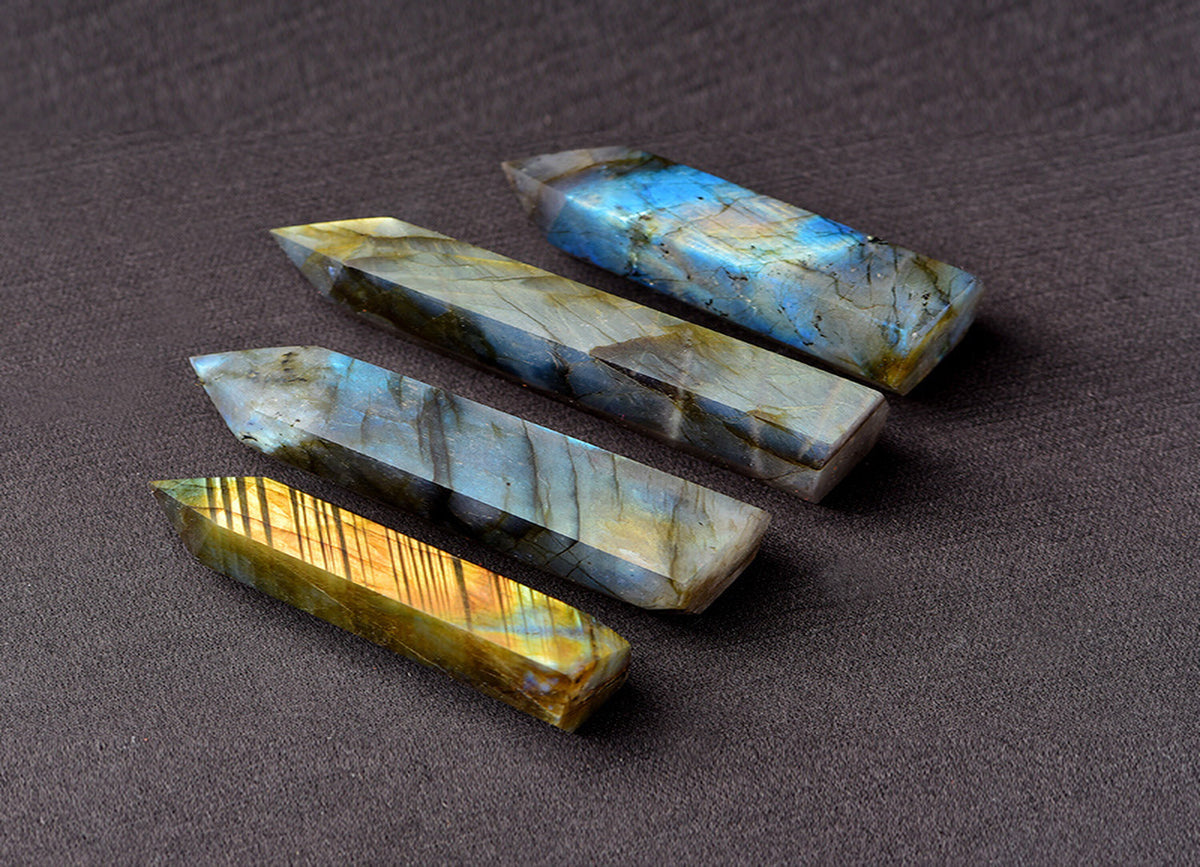 Labradorite obelisk tower crystal from GemstoneGO, showcasing iridescent gray and blue hues with polished facets.