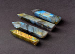 Labradorite obelisk tower crystal from GemstoneGO, showcasing iridescent gray and blue hues with polished facets.