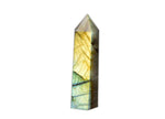 Labradorite obelisk tower crystal from GemstoneGO showcasing iridescent flashes and polished stone on a white background.
