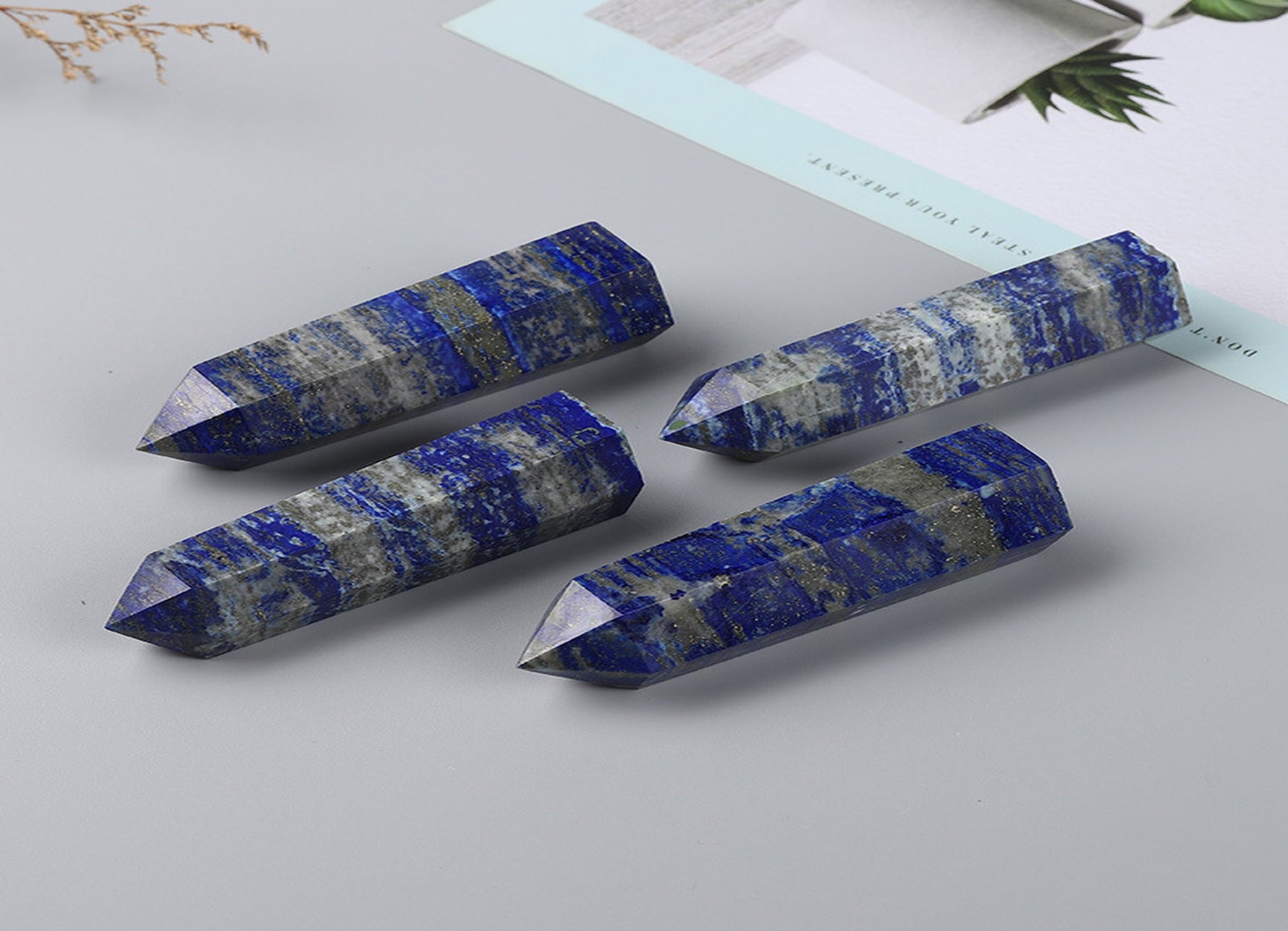 Lapis Lazuli obelisk tower crystal from GemstoneGO with deep blue color and gold pyrite inclusions, polished and smooth surface.