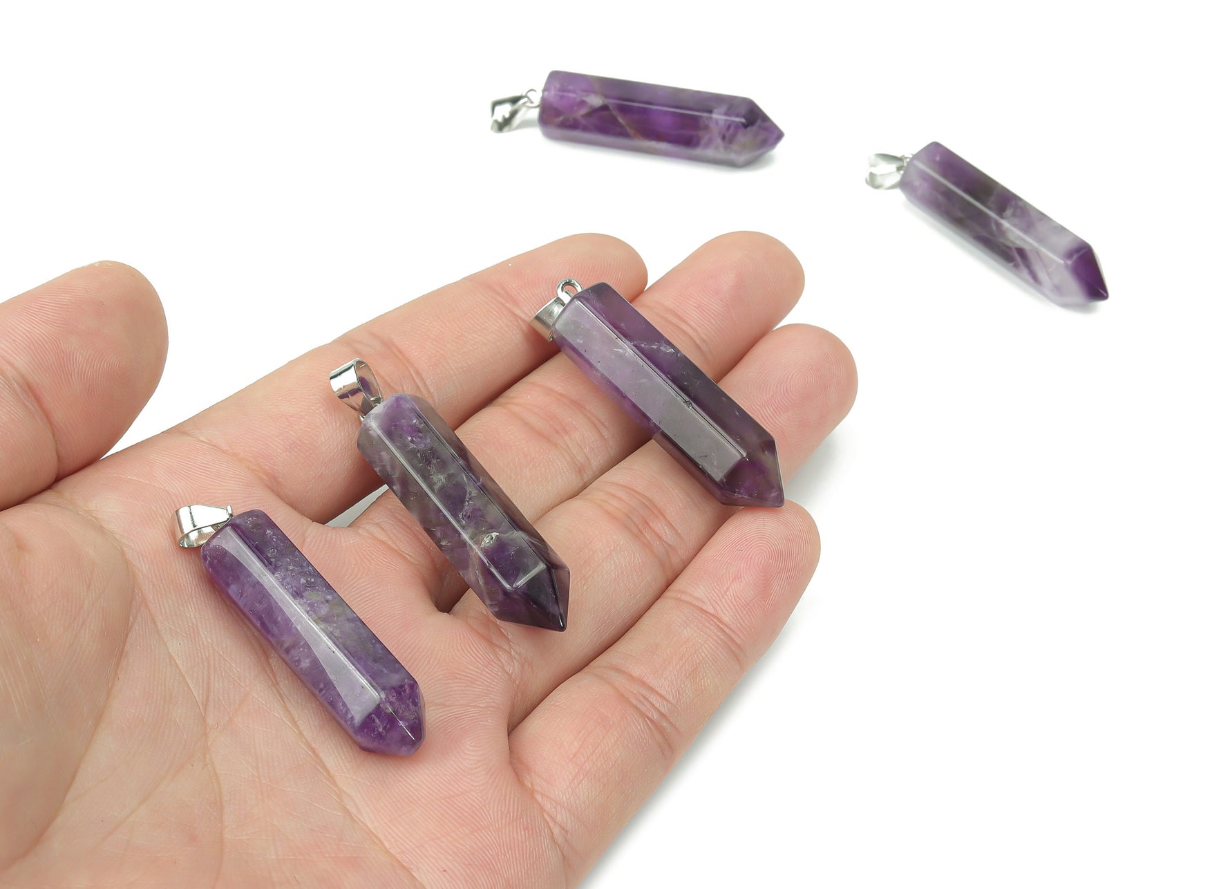 Amethyst point crystal pendant from GemstoneGO, showcasing a purple gemstone with natural crystal formations, ideal for jewelry making.