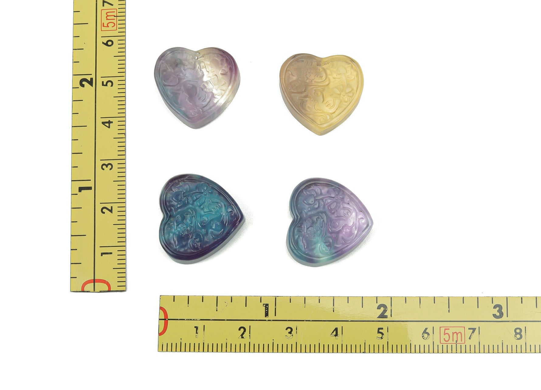Polished fluorite heart gemstone carving by GemstoneGO, displaying vibrant purple and green hues with smooth, detailed surface.
