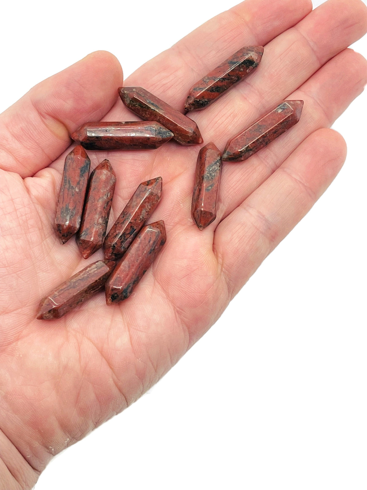 Red sesame terminated carved point gemstone, 33mm, from GemstoneGO, showcasing intricate carving and vibrant red sesame color.