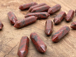 Red sesame terminated carved point gemstone from GemstoneGO, 33mm length with intricate carving and vibrant red color.