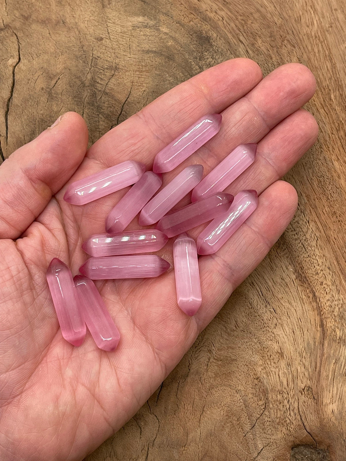 Pink Cats Eye gemstone carved point, 33mm, from GemstoneGO, featuring a polished carved cat's eye pattern on a pink stone.