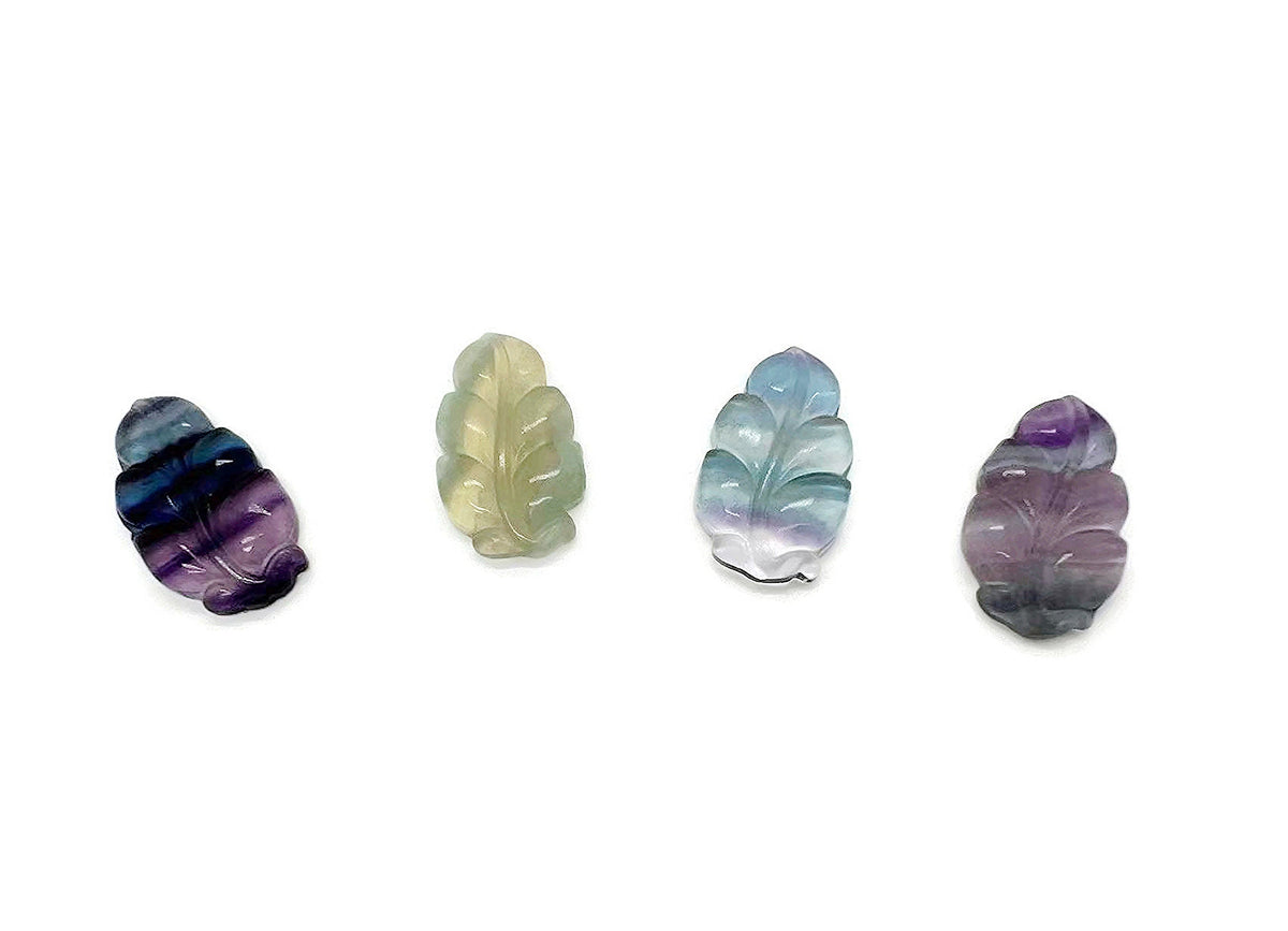 Fluorite leaf carving gemstone from GemstoneGO showing a vibrant green and purple carved leaf design on smooth polished stone.