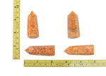Sunstone obelisk tower crystal by GemstoneGO, showcasing warm orange hues and natural stone texture on a white background.