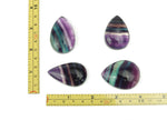 Colorful fluorite crystal carving gemstone from GemstoneGO, showcasing vibrant purple, green, and blue hues with intricate natural patterns.