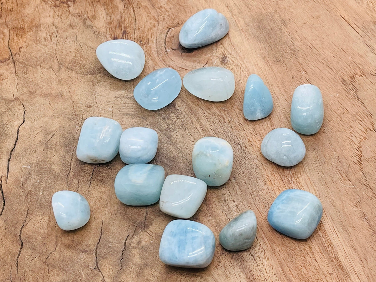 Aquamarine tumbled gemstone from GemstoneGO, showing a smooth, polished blue-green stone with natural variations and a glossy surface.