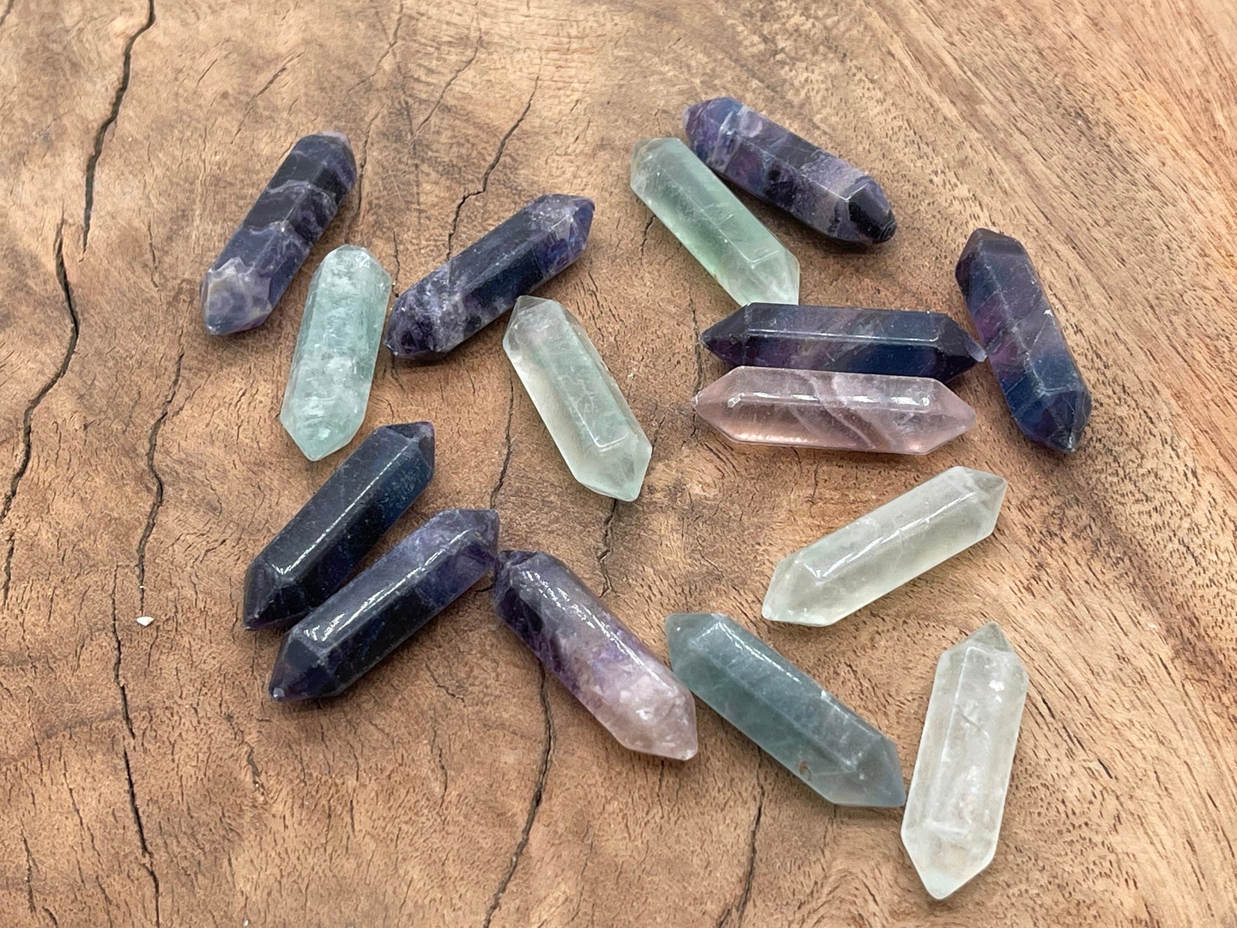 A 33mm fluorite terminated carved point gemstone from GemstoneGO, displaying vibrant purple and green hues with natural banding.