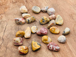 Tumbled Crazy Lace Agate stone from Mexico, showcasing vibrant patterns and colors, used for jewelry or decorative purposes.
