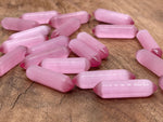 Pink Cats Eye gemstone carved point, 33mm, from GemstoneGO showcasing a polished, carved cabochon with vibrant pink and chatoyancy.