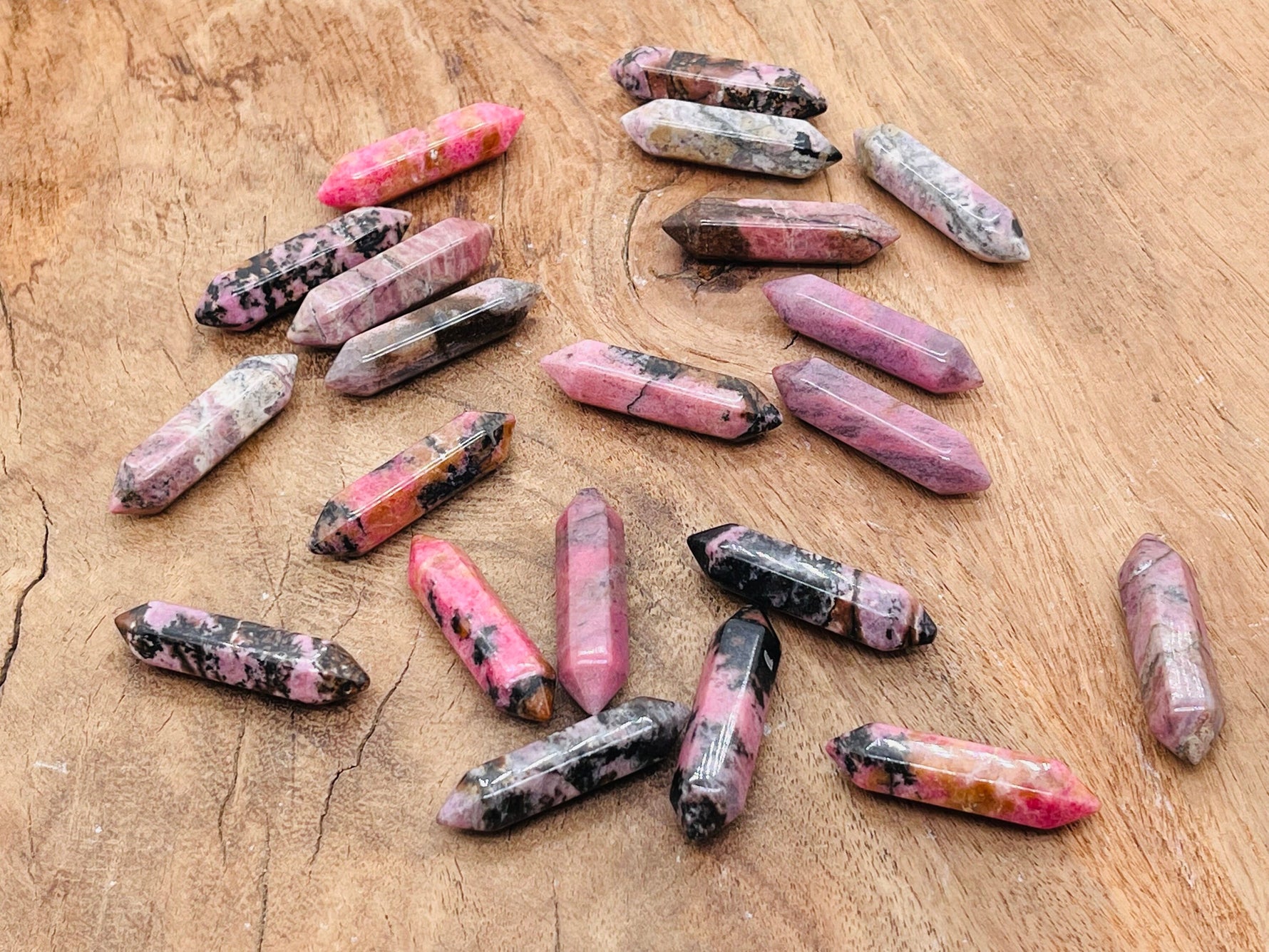 Rhodonite terminated carved crystal point, 33mm, from GemstoneGO featuring pink and black layered mineral pattern.