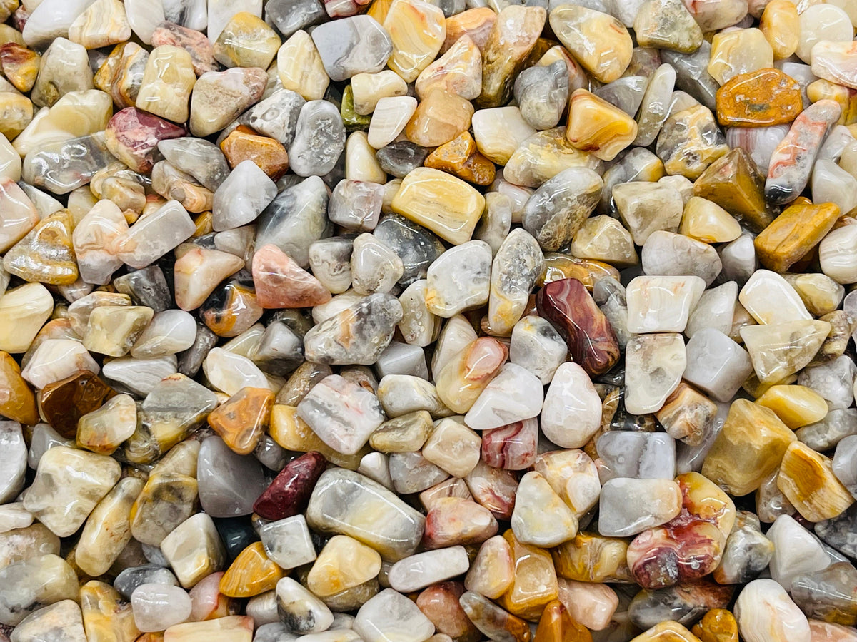 Assorted Crazy Lace Agate crystal chips, 5-7mm semi-tumbled Mexican agate stones in a bulk package, natural gemstone display.