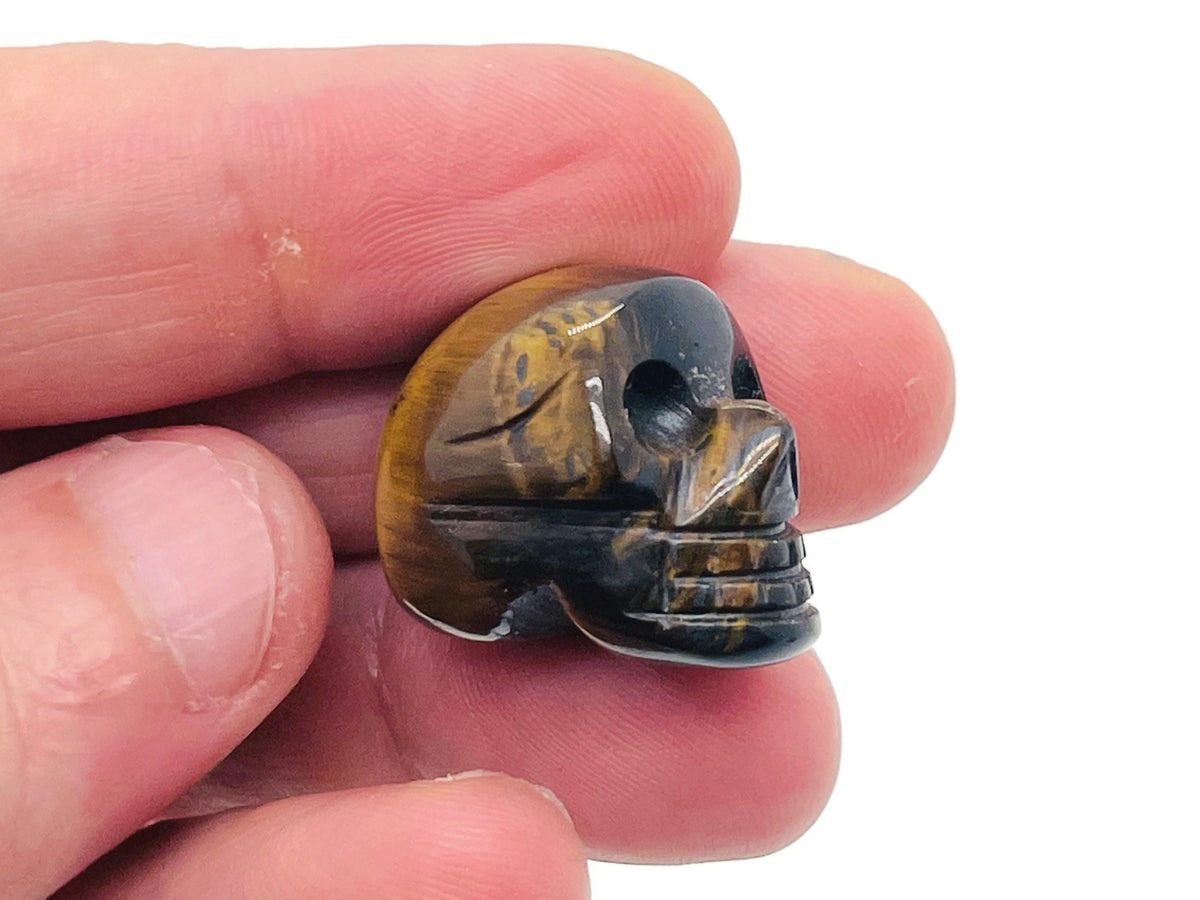 Tiger Eye skull gemstone carved sculpture, 25mm, detailed natural stone from GemstoneGO showcasing a polished skull design.